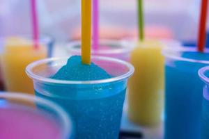 granita slush, une boisson glacée fruitée frappée dans une tasse en plastique avec une paille. dessert sucré et rafraîchissant photo