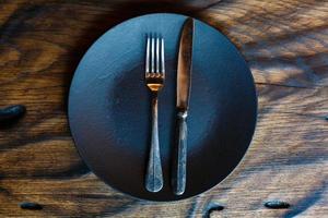 assiette vide avec couteau et fourchette sur une table en bois vintage photo