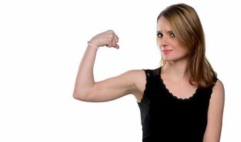 portrait de jeune belle femme lorgnant à la caméra montrant son muscle.isolé sur blanc photo