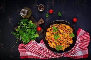 pâtes conchiglie. coquilles de pâtes italiennes aux champignons, courgettes et sauce tomate. vue de dessus photo