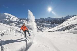 skieur hors-piste soulève la neige sur les skis photo