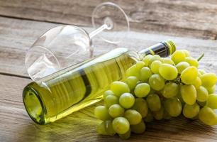 bouteille de vin blanc avec grappe de raisin photo