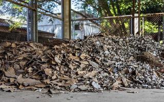 une grande quantité de feuilles mortes sont entassées dans l'ancienne salle de structure de grille en acier. photo