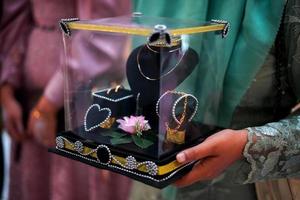 une femme tenant une boîte cadeau de mariage lors d'une cérémonie de mariage traditionnelle en indonésie photo