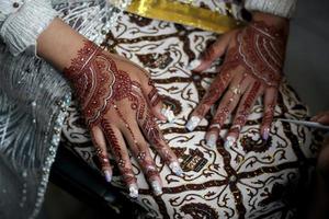 belle mariée montrant du henné sur ses mains une cérémonie de mariage traditionnelle en indonésie photo