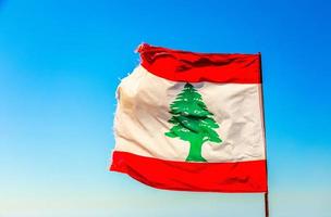 Libanais rouge et blanc avec drapeau vert cèdre agitant au vent avec ciel bleu, Byblos, Liban