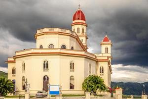 Basilique en l'honneur de Notre-Dame de la Charité avec des nuages de tonnerre noir au-dessus, El Cobre, Santiago de Cuba, Cuba photo