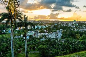 panorama du coucher du soleil de la ville cubaine avec des palmiers au premier plan, santa clara, cuba photo