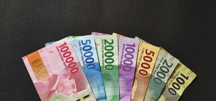 1000, 2000, 5000, 10000, 20000, 50000 et 100000 roupies indonésiennes. collection de billets de banque roupie indonésienne isolée sur fond noir. photo