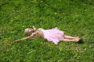 adorable petite fille s'amuse dans un verger de pommiers en fleurs photo