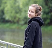 portrait de jeune fille souriante. belle femme debout une personne en plein air. une femme gaie, aux longs cheveux bruns et aux yeux bruns a une émotion positive liberté d'activité de loisirs dans un parc naturel. photo