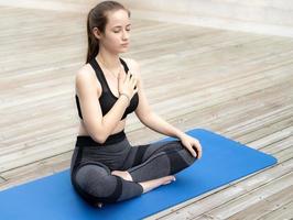 belle femme pratiquant le yoga en plein air dans le parc naturel tranquille. l'activité de loisir de la femme est la méditation, l'exercice de relaxation et de pleine conscience pour un mode de vie sain et une spiritualité paisible. photo