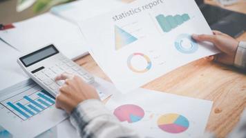 les gens d'affaires lisent des rapports de graphiques de statistiques d'entreprise, pour analyser et améliorer la stratégie d'entreprise, gérer les documents financiers et marketing, mettre à jour les comptes budgétaires annuels, les données de croissance de l'entreprise. photo