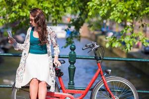 jeune femme heureuse avec un plan de ville à vélo dans une ville européenne photo