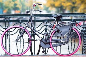 vélo rose sur le pont à amsterdam, pays-bas. belle vue sur les canaux en automne photo