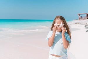 jolie petite fille à la plage pendant les vacances d'été photo