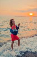 portrait de mode en plein air d'une fille élégante portant une veste en jean sur la plage. photo