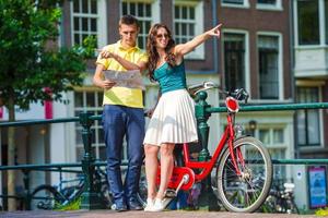 couple de jeunes touristes regardant la carte avec des vélos dans la ville européenne photo