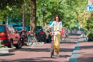 heureuse jeune femme à vélo à amsterdam photo