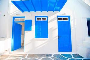 maisons traditionnelles aux portes bleues dans les rues étroites de mykonos, grèce. photo