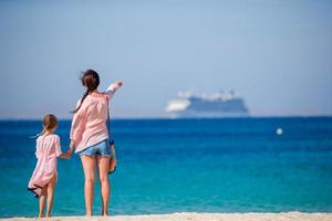 jeune belle mère et sa petite fille adorable à la plage tropicale regardant la mer photo