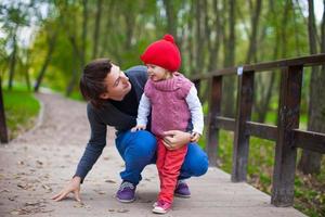 portrait de jeune père marchant avec sa jolie fille dans le parc d'automne photo