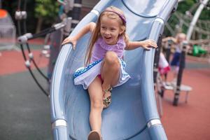 petite fille monte sur la colline dans un parc d'attractions photo