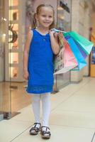 jolie fille de mode tenant des sacs à provisions et marchant au centre commercial photo