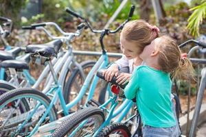 petites filles adorables s'amusant près des vélos sur un complexe exotique photo