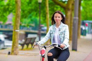 jeune femme heureuse à vélo dans la ville européenne photo