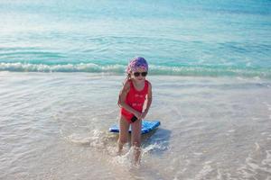 adorable petite fille dans la mer en vacances à la plage tropicale photo