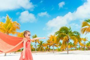 petite fille mignonne jouant au super-héros sur une plage tropicale photo