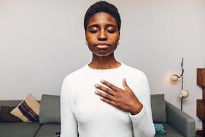 femme noire sentant son coeur à la maison photo