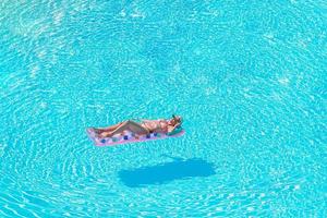 belle jeune femme relaxante dans la piscine. photo
