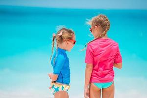 les petites filles amusantes et heureuses s'amusent beaucoup sur la plage tropicale en jouant ensemble photo