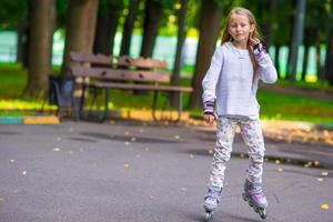 petite fille en patins à roulettes dans un parc photo