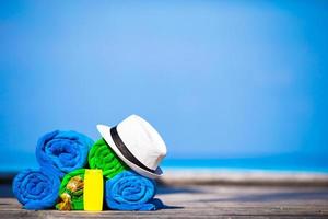 concept d'accessoires de plage et de vacances d'été - gros plan de serviettes colorées, chapeau, lunettes de natation et crème solaire photo