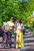 couple de jeunes touristes regardant la carte avec des vélos dans la ville européenne photo