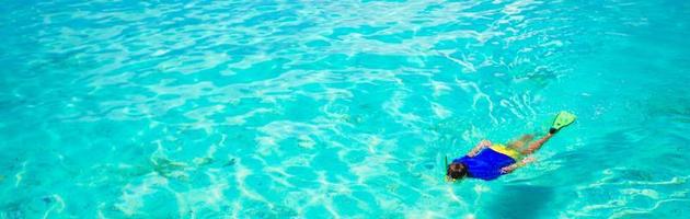 jeune homme plongée en apnée dans des eaux turquoises tropicales claires photo