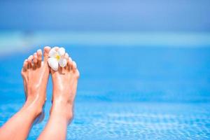 gros plan des pieds féminins sur la plage blanche photo