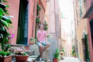 jeune homme touriste à cinque terre. jeune homme caucasien marchant dans la vieille rue de vernazza photo