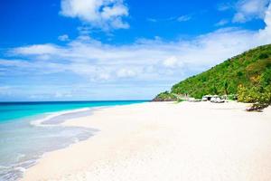 plage tropicale idyllique avec sable blanc, eau de mer turquoise et ciel bleu sur l'île des caraïbes photo