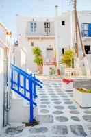 belles rues avec balcons bleus, escaliers et fleurs en pots. belle architecture extérieure de bâtiment de style cycladique. photo