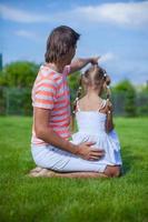 vue arrière du père avec sa fille assise dans la cour à l'extérieur photo