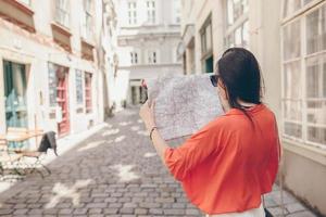 jeune femme avec un plan de ville en ville. fille touristique de voyage avec carte à vienne à l'extérieur pendant les vacances en europe. photo