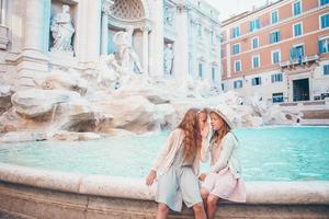 adorables petites filles au bord de la fontaine de trevi à rome. photo