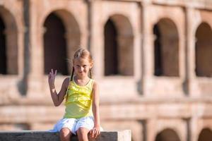 adorable petite fille active s'amusant devant le colisée à rome, italie. enfant passant son enfance en europe photo