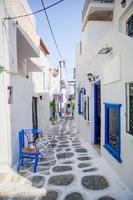 les rues étroites de l'île aux balcons bleus, escaliers et fleurs. belle architecture extérieure de bâtiment de style cycladique. photo