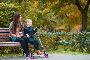 adorable petite fille avec maman profiter de la journée d'automne dans le parc d'automne à l'extérieur photo