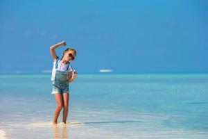 adorable petite fille heureuse s'amuser en vacances à la plage photo